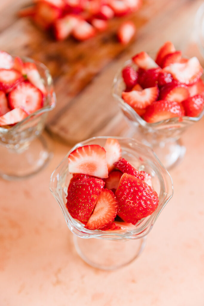 Vanilla cake topped with fresh strawberry slices in small glass cups.