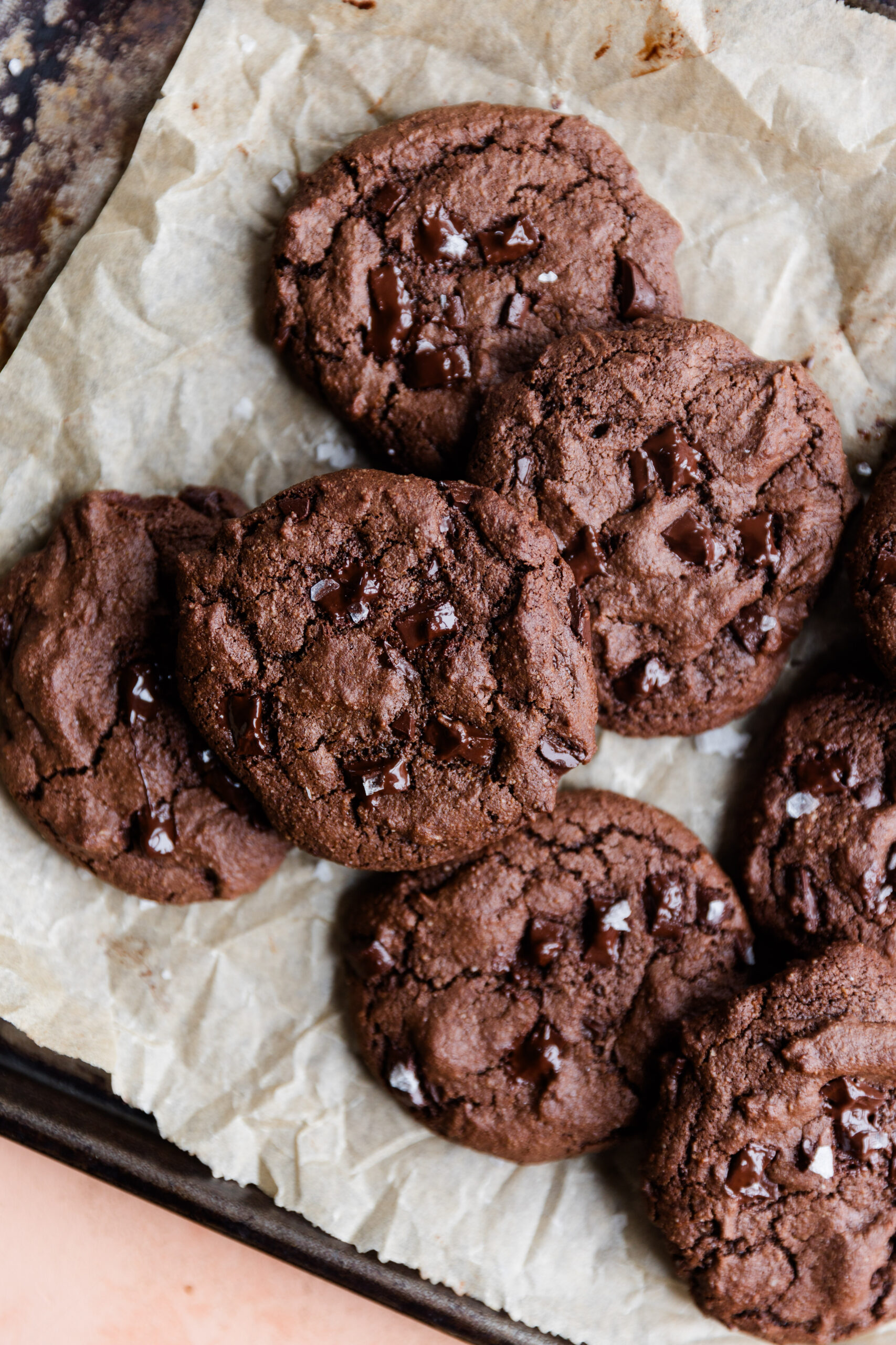 Overhead picture of double chocolate chip cookies on a parchment paper lined baking sheet.