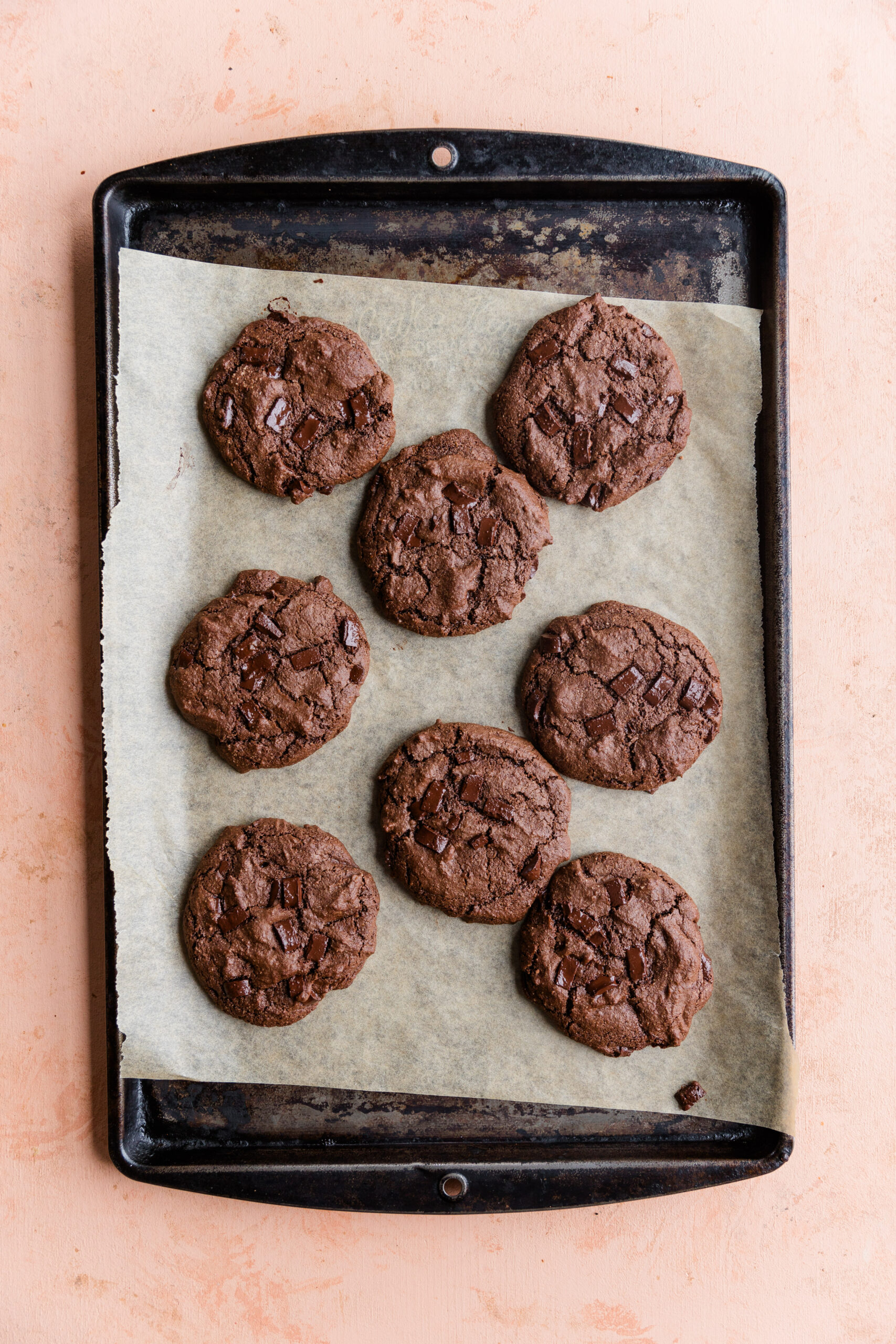 Double chocolate chip cookies on a parchment paper lined baking sheet.