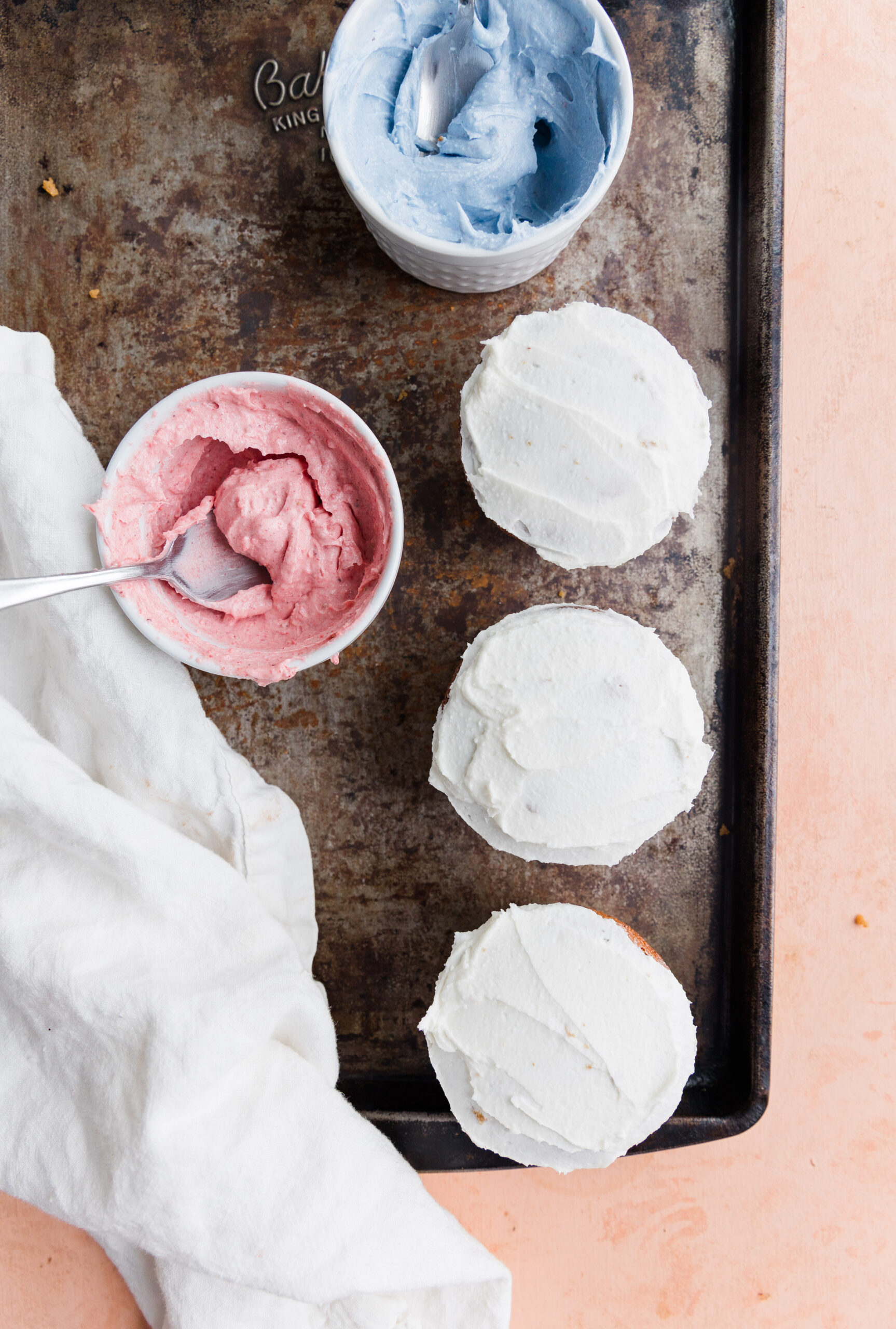 Gender reveal cupcakes filled with colorful frosting and topped with white frosting.