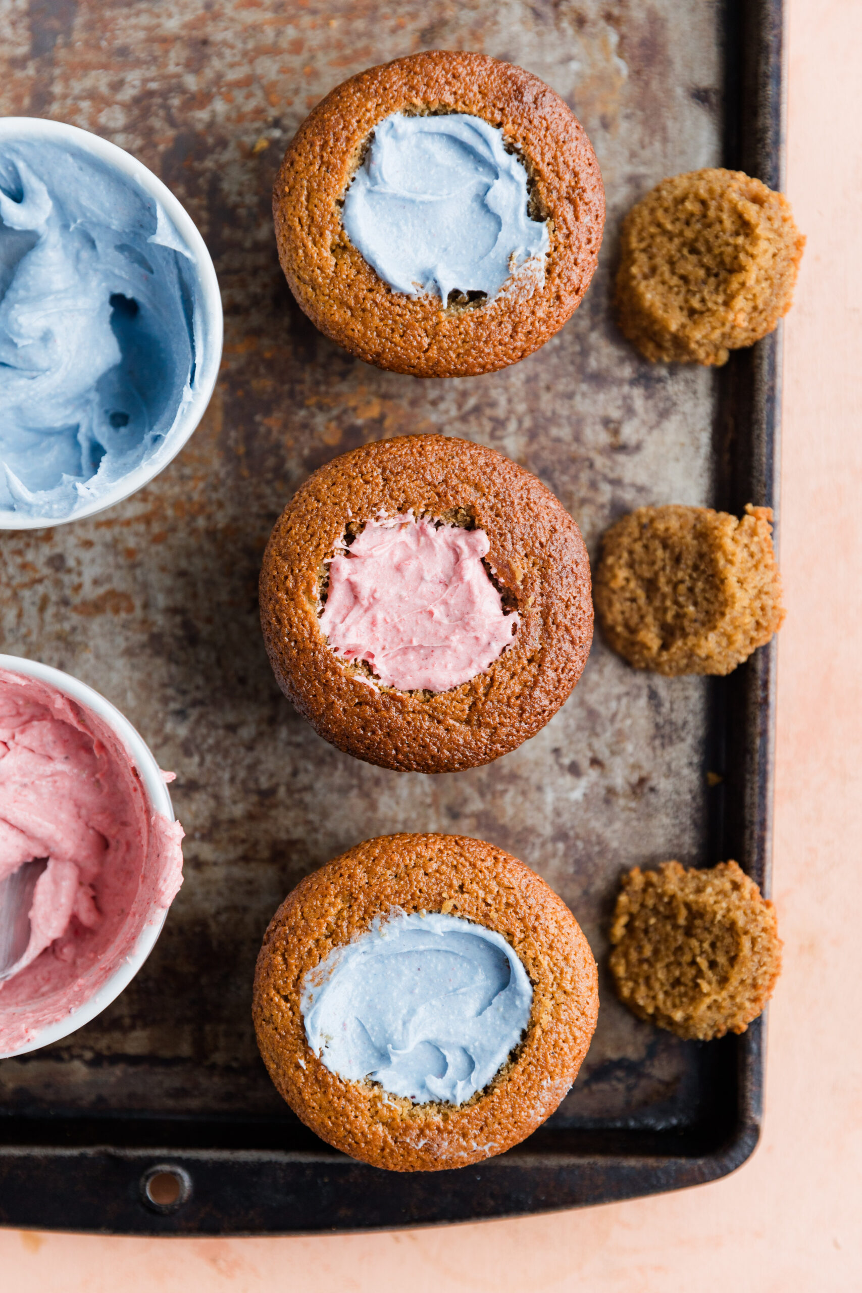 Vanilla cupcakes filled with blue frosting and pink frosting for gender reveal.