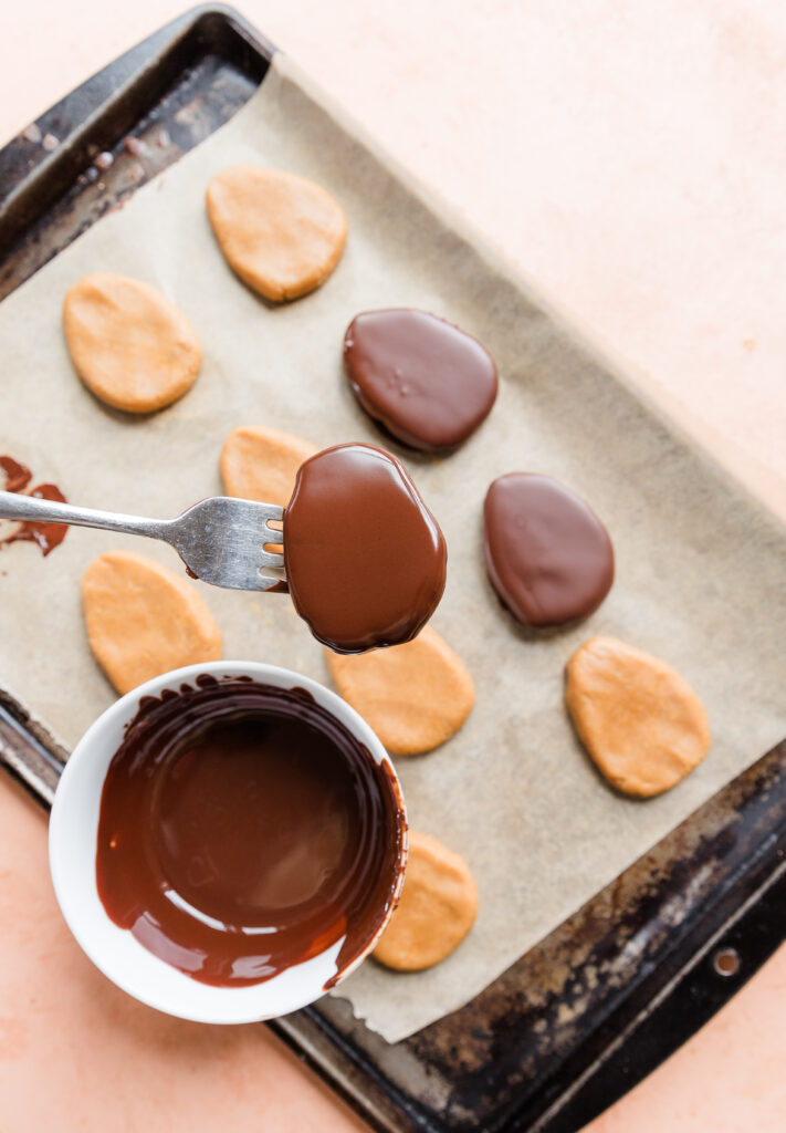 Fork holding chocolate dipped copycat reece's egg.